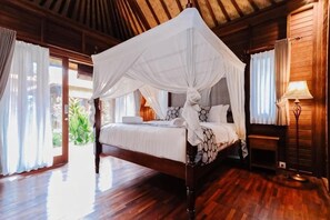 A four-poster bed with a canopy, wooden flooring, and a bedside table with a lamp. - The Lavana Jhonny Kibung Villas Lembongan (Bali)