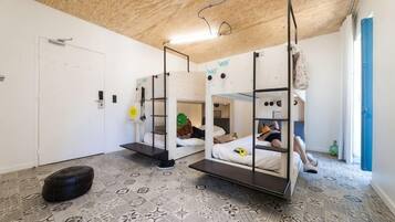 Quarto com beliches, piso estampado e teto de madeira.