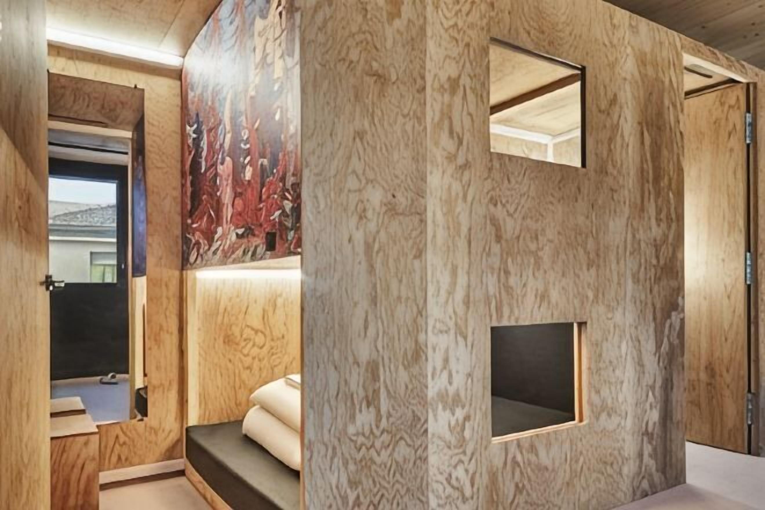 A room with wooden paneling, a small window, and a built-in bench.