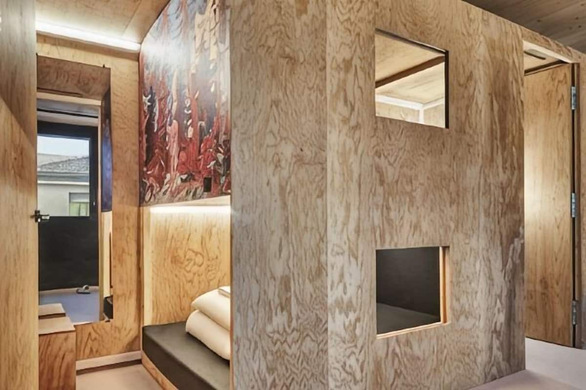 A room with wooden paneling, a small window, and a built-in bench.
