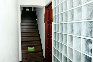 Una scala conduce a una stanza con finestre a vetro smerigliato e una porta in legno.