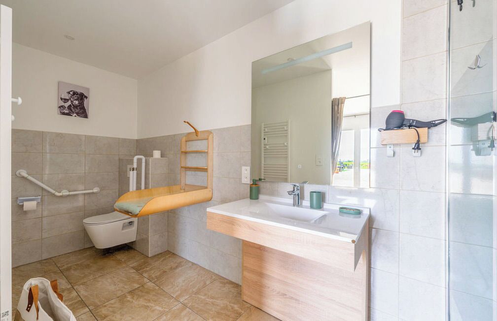 A modern bathroom with a toilet, sink, and shower.