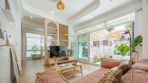Un salon moderne avec un canapé, un téléviseur et des meubles en bois.