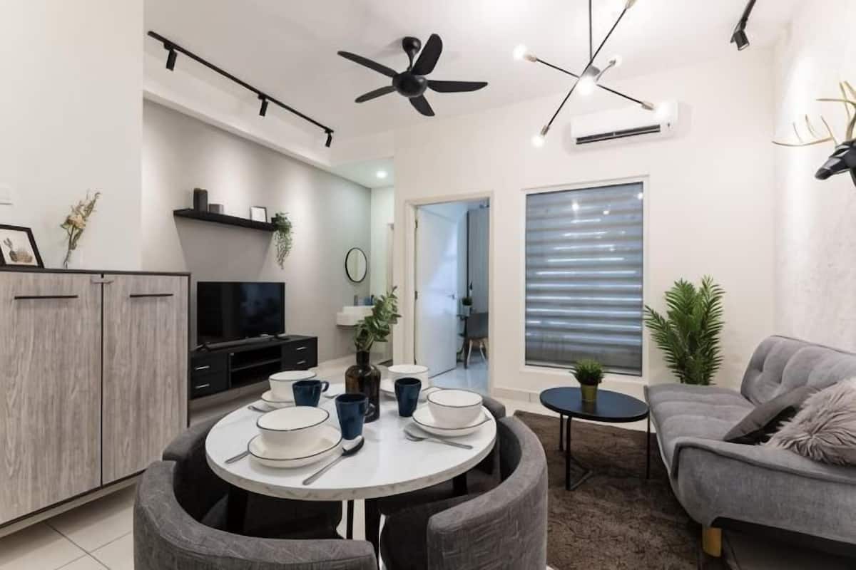 A modern living space with a dining area, a sofa, a ceiling fan, and a television.