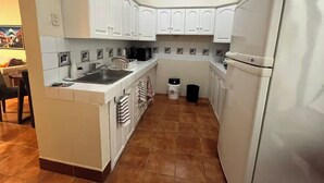 A compact kitchen with white cabinets, a sink, and a refrigerator. - Excellent location in Antigua for 4 guests (Antigua Guatemala)