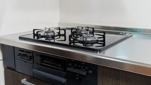 A kitchen with a gas stove, dishwasher, and a stainless steel countertop. - Oyama・Diamond・Yu (Tokyo)