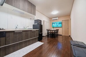 Una cucina moderna con mobili in legno, lavastoviglie integrata e zona pranzo con tavolo e sedie.