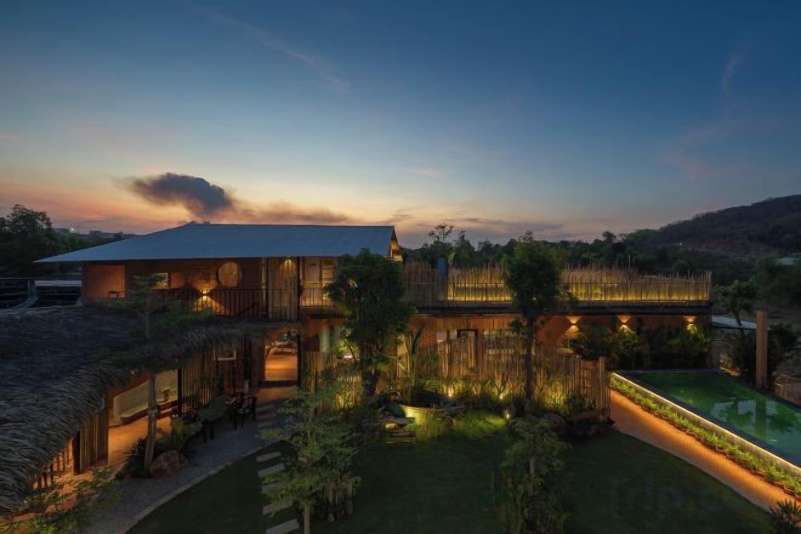 A modern house with a large patio area, a swimming pool, and a well-maintained garden.