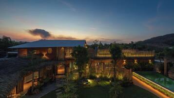 A modern house with a large patio area, a swimming pool, and a well-maintained garden.