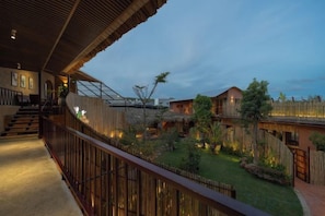 A hotel with a balcony, a staircase, and a well-maintained garden. - Chuon Chuon Retreat (Phu Thuy)