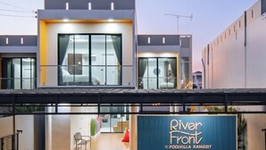 A modern hotel with a prominent sign reading "River Front" and "Poolvilla Rangsit". - Riverfront Pool Villa Rangsit Klong 4 (Thanyaburi)
