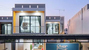 A modern hotel with a prominent entrance, large windows, and a visible outdoor seating area.