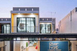 A modern hotel with a prominent entrance, large windows, and a visible outdoor seating area.