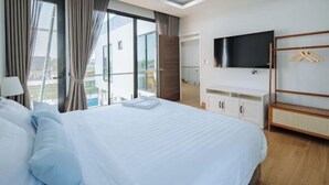 A hotel room with a large bed, a TV mounted on the wall, and a balcony with curtains. - Riverfront Pool Villa Rangsit Klong 4 (Thanyaburi)