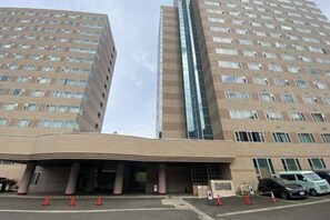 A multi-story hotel with a modern facade, large windows, and a covered entrance area. - Lodge noel (Minamiuonuma)