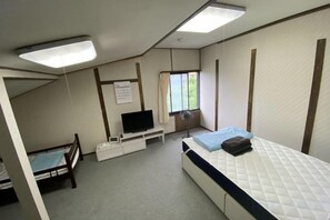 A compact room with a bed, a TV, a desk, and a window. - Lodge noel (Minamiuonuma)