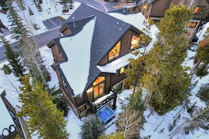 Un immeuble à plusieurs étages, dont le toit est recouvert de neige et sur lequel s’est formée une grande accumulation de neige en forme de triangle.