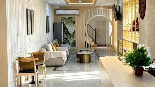 Eine moderne Hotelhalle mit Rezeption, Sitzgelegenheiten und einer Treppe.
