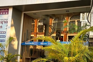 A hotel entrance with a glass door, a welcome sign, and a signboard advertising a water treatment service. - ZHIYUANTA HOTEL (Vientiane)