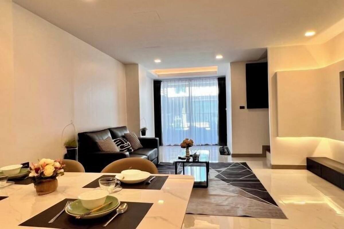 Ein modernes Wohnzimmer mit Essbereich, einer Couch und einem Couchtisch.