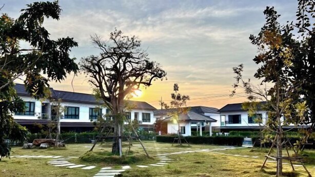 A residential area with modern houses, a grassy lawn, and a stone pathway. - Pattaya Tay Emperor Holiday townhouse (Pattaya)