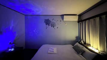 A bedroom with a bed, a wall-mounted air conditioner, and a window with curtains.