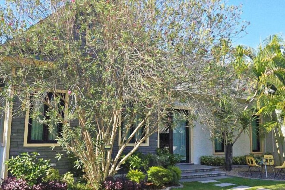 A house with a front porch, a small garden, and a clear sky.