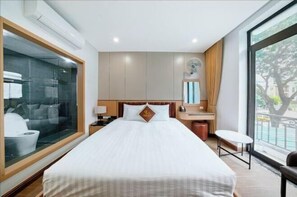 Une chambre d’hôtel avec un grand lit, un bureau, une chaise et une fenêtre donnant sur un beau paysage.