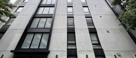 Un edificio moderno con una fachada simétrica, múltiples ventanas y una entrada central.