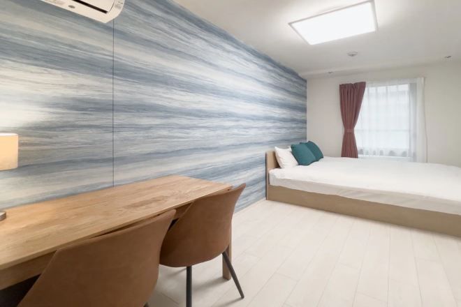 A modern bedroom with a bed, a desk, and a chair.