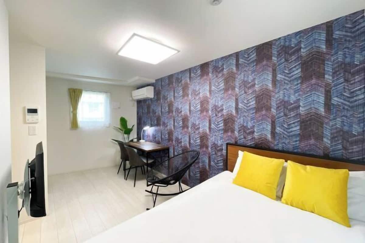 A hotel room with a bed, a desk, and a chair.