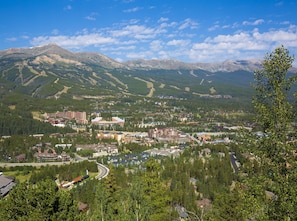 Il s’agit d’une ville de montagne où se côtoient des bâtiments résidentiels et commerciaux, notamment un hôtel imposant à plusieurs étages, situé en plein centre.