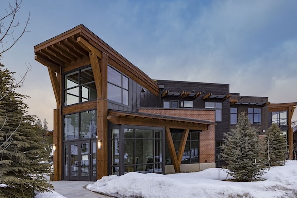 Un bâtiment moderne à plusieurs étages, doté de grandes fenêtres en verre et de poutres en bois.