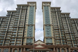 Un edifici residencial alt amb nombroses balconades, una entrada central i una façana simètrica.