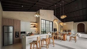 A modern kitchen with a central island, wooden bar stools, and pendant lighting. - MDF Villa Canggu (Bali)