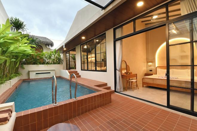 Ein modernes Hotelzimmer mit privatem Pool, großen Fenstern und einer gemütlichen Sitzecke.