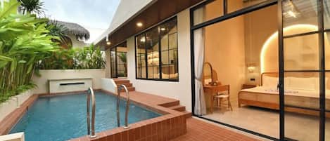 Une chambre d’hôtel moderne dotée d’une piscine privée, de grandes fenêtres et d’un coin salon confortable.