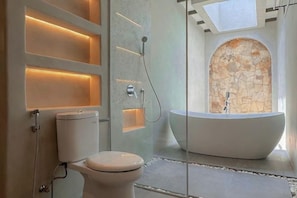 A modern bathroom with a freestanding bathtub, a toilet, and a shower area. - MDF Villa Canggu (Bali)