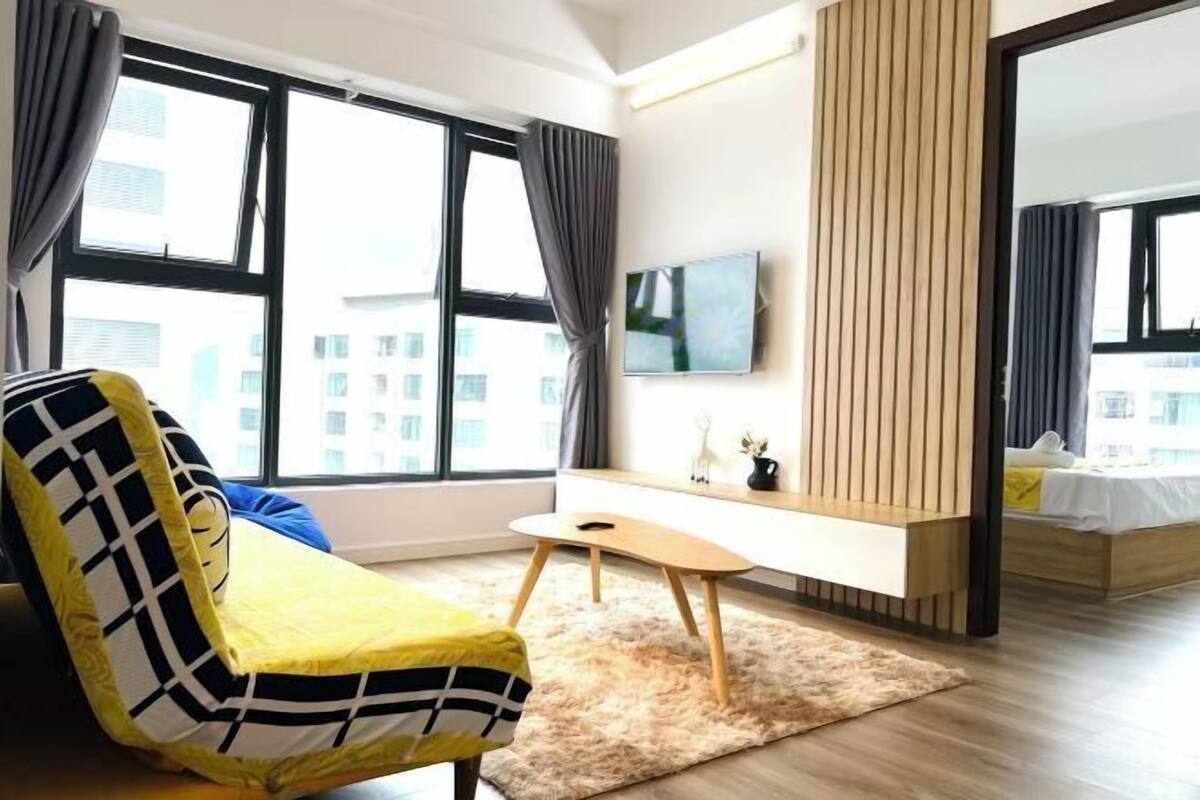 Une chambre d’hôtel moderne dotée d’une grande fenêtre, d’un canapé, d’un bureau et d’un lit.