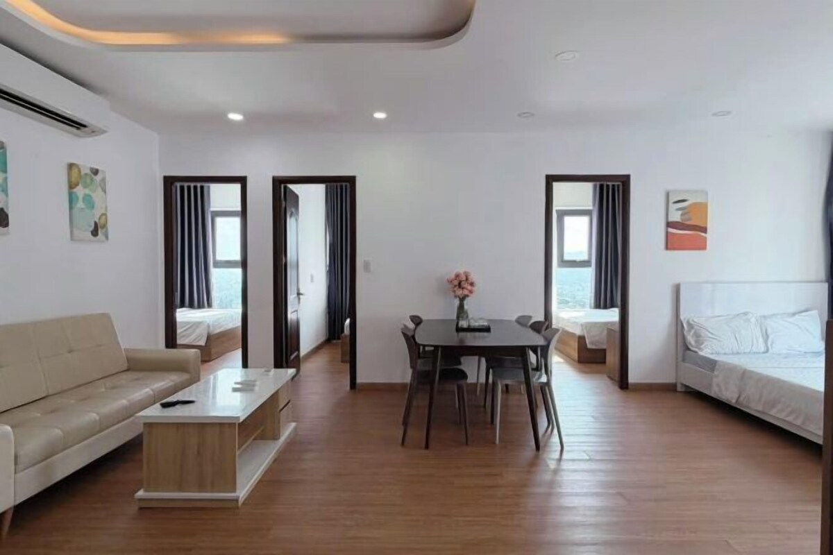 A modern hotel room with a sofa, a dining table, and a bed.