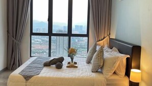 A hotel room with a large window, a bed with pillows and a blanket, a bedside lamp, and a vase with flowers. - 7 Pax Genting View Nearby Mont Kiara Desa Park 500Mbps Netflix (Kuala Lumpur)