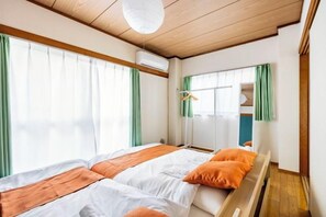 A hotel room with a bed, a wardrobe, and a window with curtains. - Nishikameari 2 chome (Tokyo)