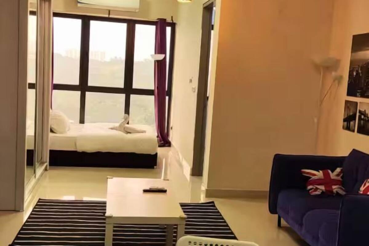 A room with a bed, a sofa, a small table, and a window with curtains.