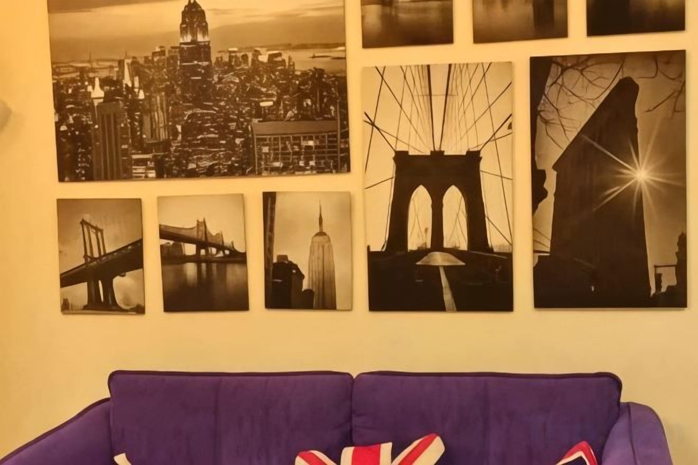 Uma parede com várias fotografias a preto e branco de paisagens urbanas e pontes.