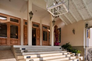 A staircase with a handrail, wooden doors, and wall-mounted lights. - The Divine Villa (Heenatigala)