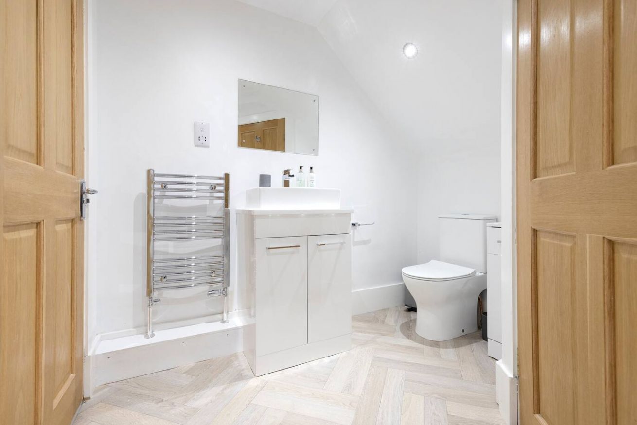 A modern bathroom with a shower, toilet, and sink.