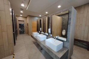 A long corridor with multiple sinks and mirrors. - K Avenue by Butter House @Sunset Seaview Cozy (Donggongon)