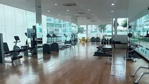 A spacious gym with exercise equipment, large windows, and a polished wooden floor. - M9 Prime Suite@H20 Medalla CittaMall SubangAirport (Petaling Jaya)