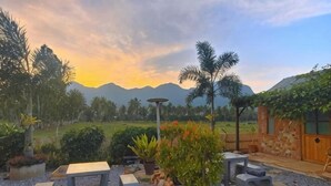 A patio area with seating, a pergola, and a view of mountains.