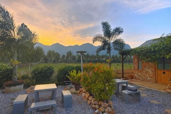 Un'area patio con posti a sedere, una pergola e vista sulle montagne.